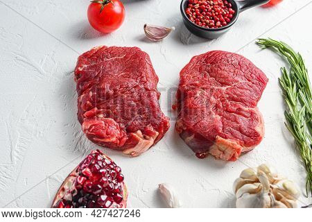 Raw Rumpsteak, Farm Beef Meat With Seasonings, Rosemary, Garlic, Garnet. White Textured Background. 