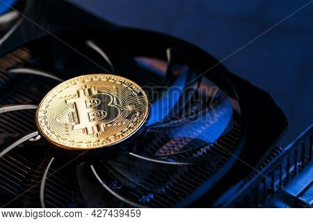 Gold Bitcoin On The Video Card Cooler On A Dark Background Top View.