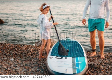 Surfing. A Preschool-age Girl Is Learning To Ride A Sap Board. Active Recreation On The Sea And The 