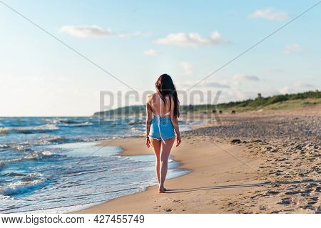 Lonely Young Woman Walking On The Beachsunset Day.beach Woman In Fashion Beachwear Relaxing Walking 