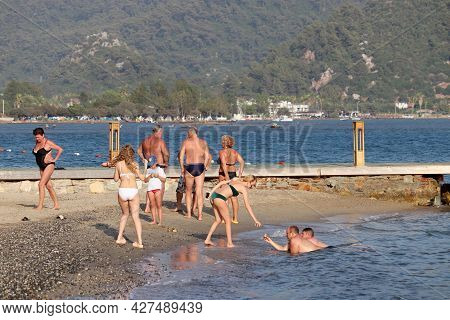 Hisaronu, Turkey​ -​ July 2021: People Having Fun On A Beach On Green Mountain Background. Tourists 