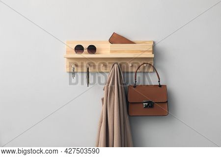 Wooden Hanger For Keys With Different Stuff On Light Grey Wall