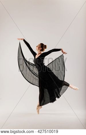 Portarit Of Sensual Professional Caucasian Callet Dancer In Body Suit And Pointes Shoes On White.