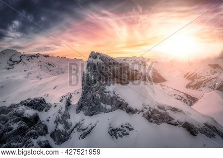 Aerial View From Airplane Of Blue Snow Covered Canadian Mountain Landscape In Winter. Colorful Orang