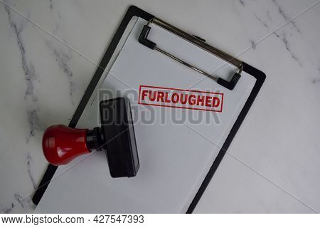 Red Handle Rubber Stamper And Furloughed Text Isolated On Wooden Table.
