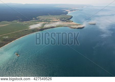 The Shore Of Lake Baikal From The Air. Beautiful Landscape Of Olkhon Island On A Summer Day. Fog Ove