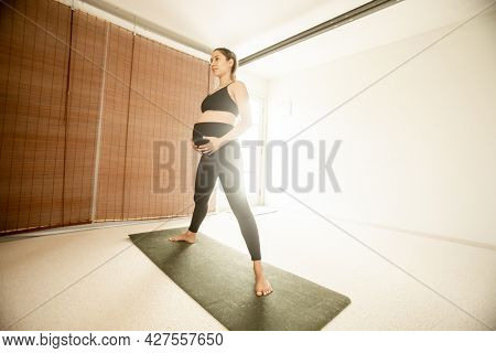 young pregnant woman practicing maternity yoga