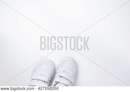 Top View Of Two White Running Shoes Partially Located At The Bottom With Free Space For Text Isolate