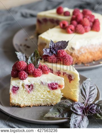 Raspberry Cheesecake Slices With Fresh Raspberries And Bazil Leaves On A Grey Plate, Whole Cheesecak