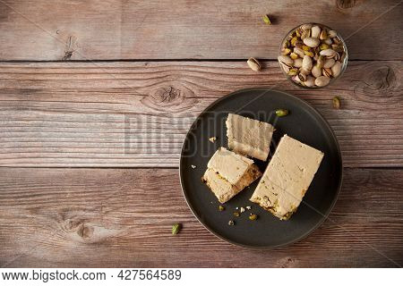 Organic Halva With Pistachios On A Wooden Surface. Traditional Middle Eastern Sweets. Jewish, turkis