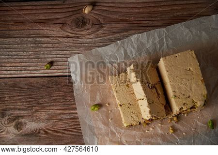 Organic Halva With Pistachios On A Wooden Surface. Traditional Middle Eastern Sweets. Jewish, turkis