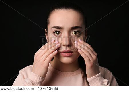Woman Checking Her Health Condition On Black Background. Yellow Eyes As Symptom Of Problems With Liv