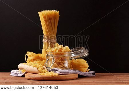 Different Types Of Raw Pasta Close-up On A Colored Background.