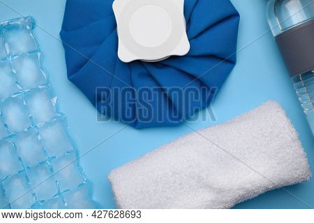Bottle Of Water, Cold Compress, Ice Pack And Towel On Light Blue Background, Flat Lay. Heat Stroke T