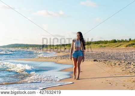 Lonely Young Woman Walking On The Beachsunset Day.beach Woman In Fashion Beachwear Relaxing Walking 