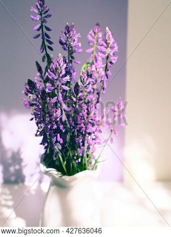Bouquet Of Purple Wild Flowers Field Bell Flowers In White Vase On White Shelf In The Bathroom. The 