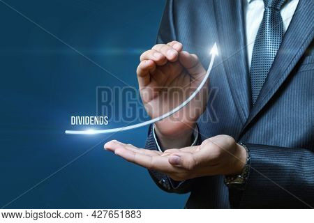 Business Dividend Profit Growth Concept. Businessman Shows An Arrow Of Growing Profits.