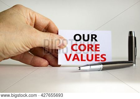 Our Core Values Symbol. White Paper With Words 'our Core Values' In Businessman Hand, Metallic Pen. 
