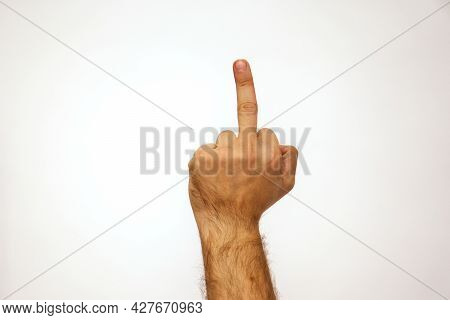 Middle Finger Gesture. Caucasian Man Holds His Hand On A White Background And Place For Text. Fuck Y