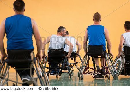 disabled war veterans in action while playing basketball on a basketball court with professional sports equipment for the disabled