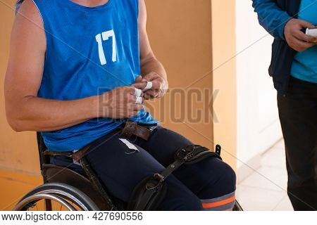 a handicapped basketball player prepares for a match while sitting in a wheelchair.preparations for a professional basketball match. the concept of disability sport