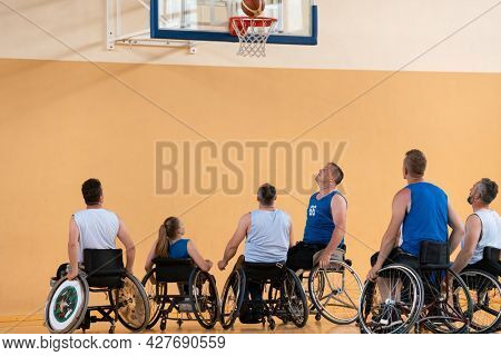 disabled war veterans in action while playing basketball on a basketball court with professional sports equipment for the disabled