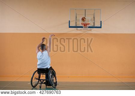 a photo of a war veteran playing basketball with a team in a modern sports arena. The concept of sport for people with disabilities