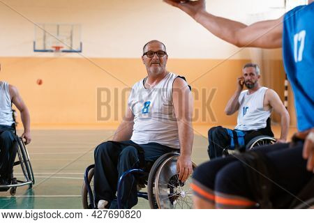 handicapped war veterans in wheelchairs with professional equipment play basketball match in the hall.the concept of sports with disabilities