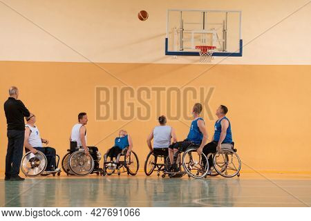 disabled war veterans in action while playing basketball on a basketball court with professional sports equipment for the disabled