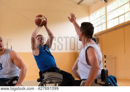 handicapped war veterans in wheelchairs with professional equipment play basketball match in the hall.the concept of sports with disabilities