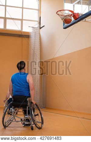 a photo of a war veteran playing basketball with a team in a modern sports arena. The concept of sport for people with disabilities