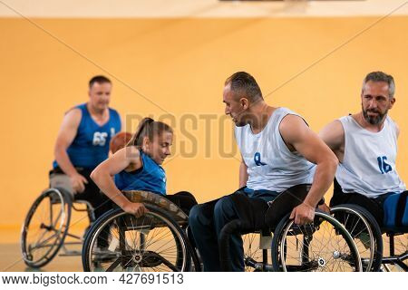 disabled war veterans in action while playing basketball on a basketball court with professional sports equipment for the disabled
