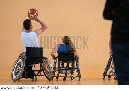 disabled war veterans in action while playing basketball on a basketball court with professional sports equipment for the disabled