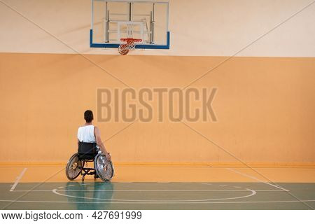 a photo of a war veteran playing basketball with a team in a modern sports arena. The concept of sport for people with disabilities