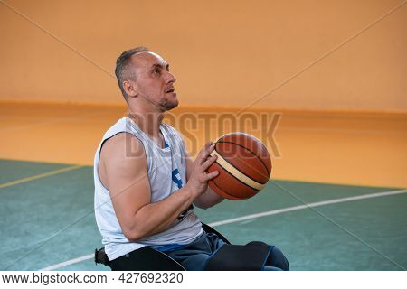 a photo of a war veteran playing basketball with a team in a modern sports arena. The concept of sport for people with disabilities