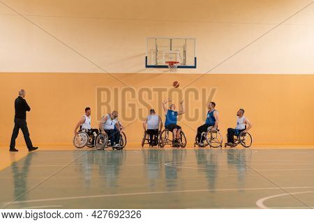 disabled war veterans in action while playing basketball on a basketball court with professional sports equipment for the disabled