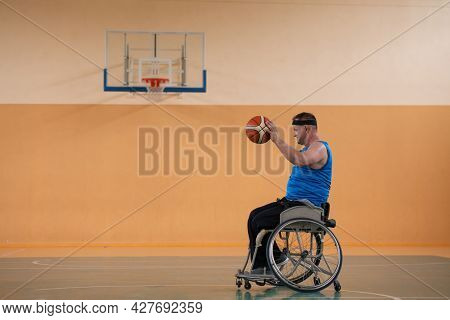 a photo of a war veteran playing basketball with a team in a modern sports arena. The concept of sport for people with disabilities