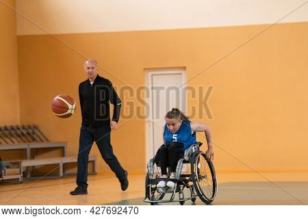 a sports basketball coach explains to a disabled woman in a wheelchair which position to play during a game