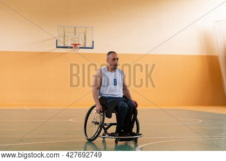 a photo of a war veteran playing basketball with a team in a modern sports arena. The concept of sport for people with disabilities