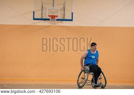 a photo of a war veteran playing basketball with a team in a modern sports arena. The concept of sport for people with disabilities