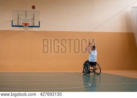 a photo of a war veteran playing basketball with a team in a modern sports arena. The concept of sport for people with disabilities