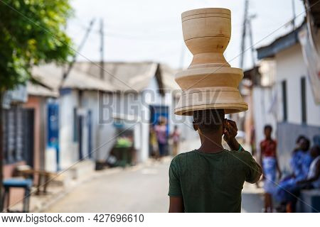 Genaral Scene Of African Woman With Things On Head And Mobile Phone In Hand