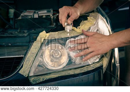 Headlight Cleaning. The Master Applies The Paste To The Cleaned Surface, Polishes The Headlights Of 