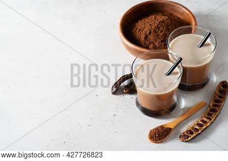 Carob Drinks In Glass With Carob Beans And Powder