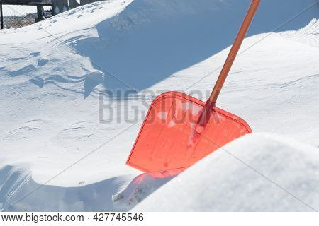 A Snow Shovel Is Stuck In A Snowdrift In Winter In Winter. Snow Removal, Cleaning The Street From Sn