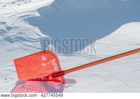 A Snow Shovel Is Stuck In A Snowdrift In Winter In Winter. Snow Removal, Cleaning The Street From Sn
