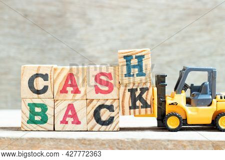Toy Forklift Hold Letter Block H, K In Word Cash Backon Wood Background