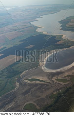 Land View Through The Airplane Window. Fields, Roads, Rivers From A Birds Eye View. Porthole. Look O