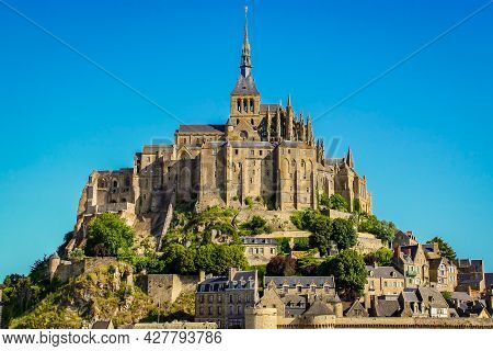 Mont Saint Michel With Its Spectacular Houses, Walls And Monastery At The Top, On A Sunny Day And Bl