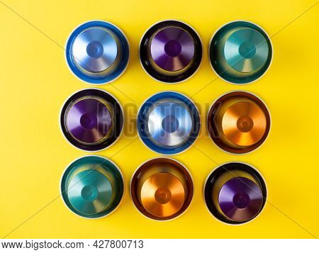 Many Aluminum Coffee Capsules Are Displayed In A Row On A Yellow Background. Food Pattern. Capsules 